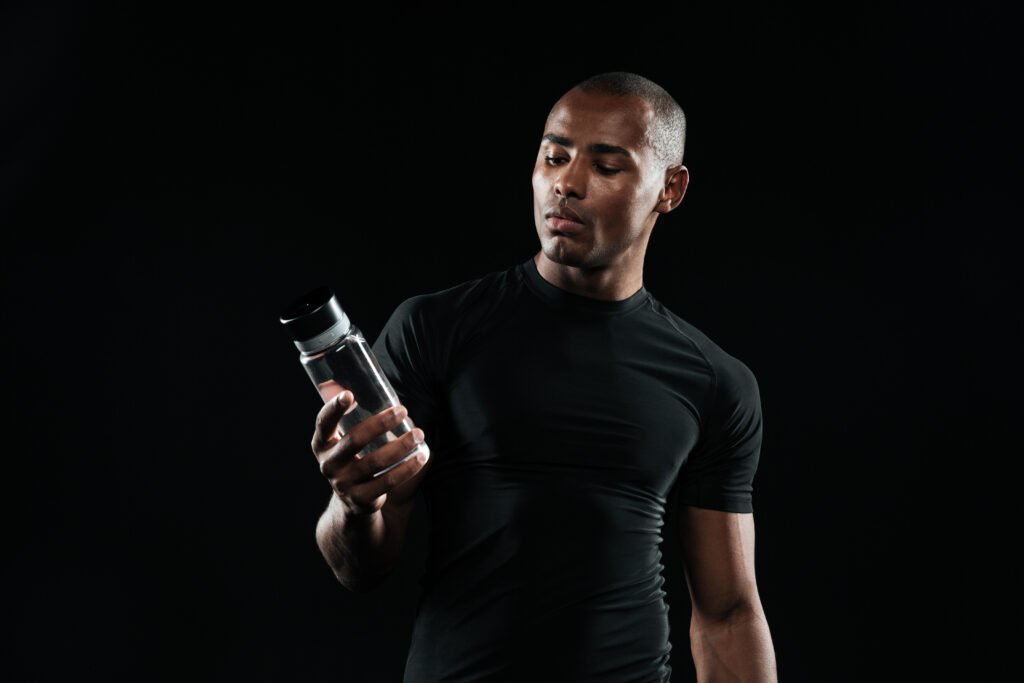 Athlete holding NITRIC BOOST ULTRA supplement before workout to boost energy and endurance