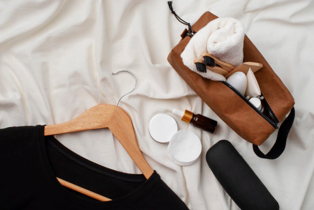 Flat lay of minimalist fashion essentials in neutral tones – shirts, trousers, coat, and leather tote.”