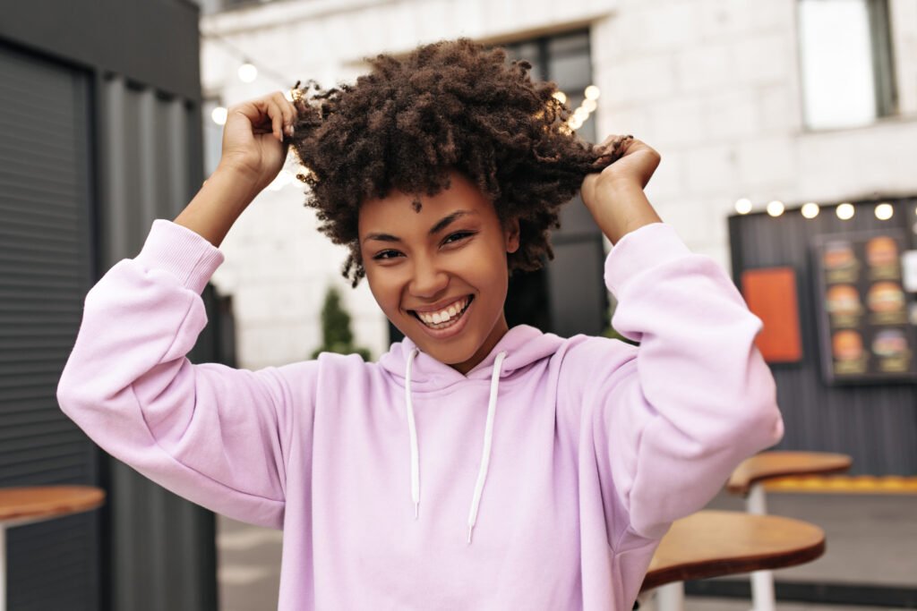 Person confidently running fingers through thick healthy hair after following the Viviscal 4D Hair Growth Cycle hair restoration program